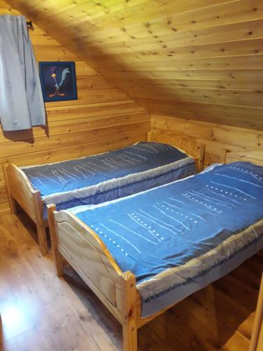 two beds in a room with wooden ceilings at Charmant chalet du Kohlberg in Dabo