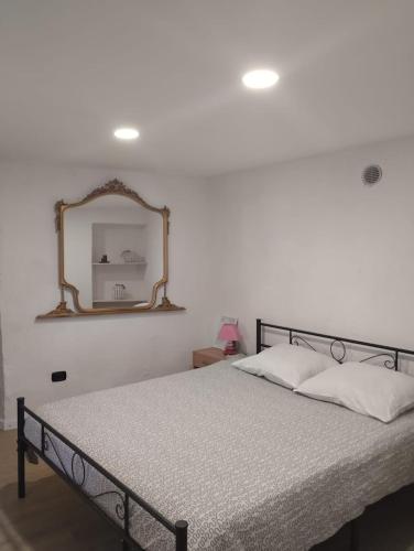 a bedroom with a bed with a mirror on the wall at LANZO IN CORTE APPARTAMENTO in Lanzo dʼIntelvi