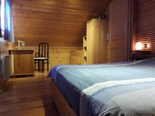 1 dormitorio con 1 cama, 1 mesa y 1 silla en Charmant chalet du Kohlberg, en Dabo