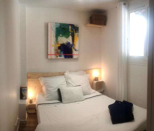 una camera con un letto bianco e una finestra di D'art d'art à Sanary a Sanary-sur-Mer