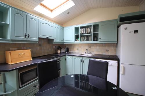 a kitchen with green cabinets and a table and chairs at City Centre Townhouse in Galway