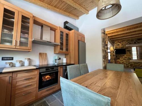 una cucina con tavolo in legno e forno di Luxury Historic Island Home with Private Garden a Poros