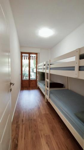 a room with two bunk beds and a wooden floor at MareBlu Appartamento in Marina di Castagneto Carducci