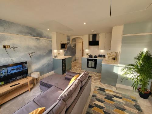 un soggiorno con divano e TV e una cucina di Sunset Point Apts - Blue Horizon Suite a Margate