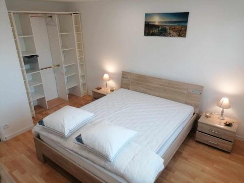 a bedroom with a bed with white sheets and two lamps at JOLIE APPARTEMENT A 5KM DE BERCK 7 COUCHAGES in Waben