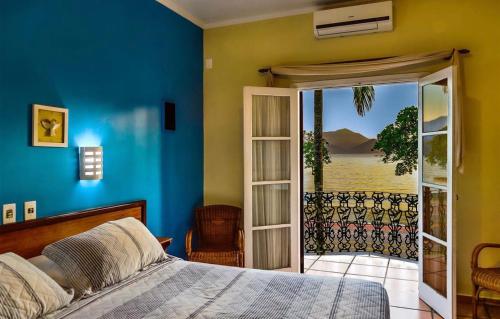 a bedroom with a bed and a sliding glass door at Hotel Villa Di Rimini in Ubatuba