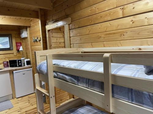 a bedroom with two bunk beds in a log cabin at Immaculate Cabin 5 mins to Inverness Dog friendly in Inverness