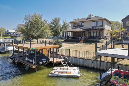 a boat is docked at a house on the water at Luxurious, Tranquil, 4BR Lakefront Villa in Mabank