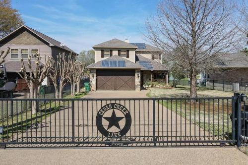 a black iron gate with a sign in front of a house at Luxurious, Tranquil, 4BR Lakefront Villa in Mabank