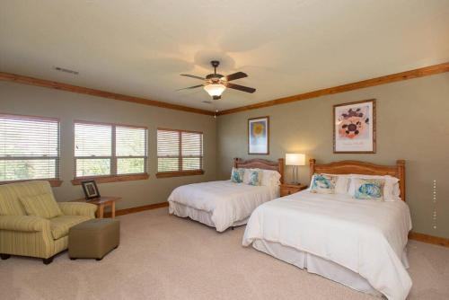 a bedroom with two beds and a ceiling fan at Luxurious, Tranquil, 4BR Lakefront Villa in Mabank