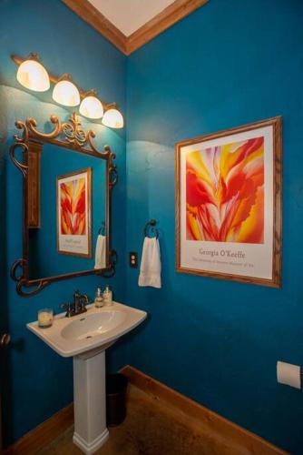 a blue bathroom with a sink and a mirror at Luxurious, Tranquil, 4BR Lakefront Villa in Mabank