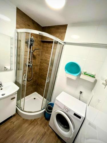 uma casa de banho com um chuveiro e uma máquina de lavar roupa em Ursus Rooms-Self Check-in em Varósvia