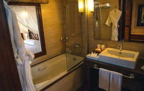 a bathroom with a tub and a sink and a shower at Suite Elisir Domina Coral Bay in Sharm El Sheikh
