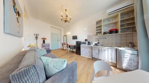 un salon avec un canapé et une cuisine dans l'établissement Les Fleurs Astoria, à Menton