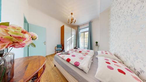 - une chambre avec un lit, une table et des fleurs dans l'établissement Les Fleurs Astoria, à Menton