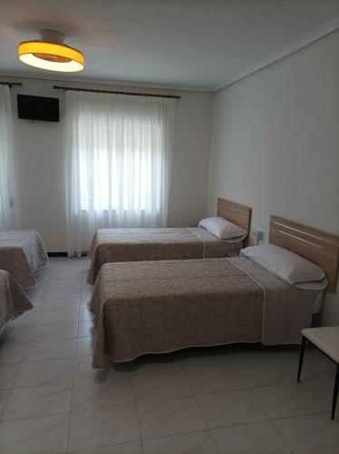 a hotel room with two beds and a television at El Ferial in Sarón