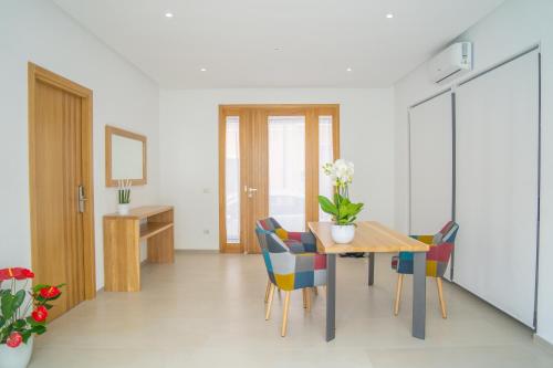 Nuova -Luxury Rooms & Apartment- في أولبيا: غرفة طعام مع طاولة وكراسي