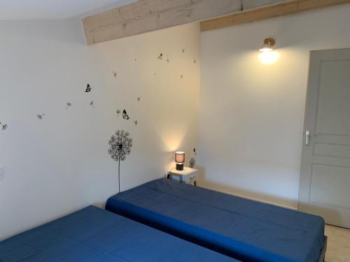 - une chambre avec 2 lits bleus et une fenêtre dans l'établissement Ambalao - Appartement 2 chambres, à Meysse