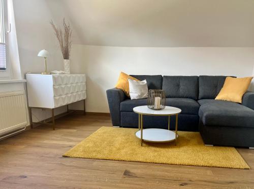 Ferienwohnung Klein & Fein في غوسترو: غرفة معيشة مع أريكة زرقاء وطاولة