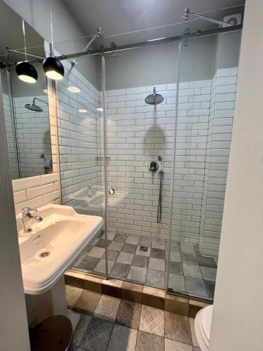 a bathroom with a glass shower and a sink at Hygge in Tatariv