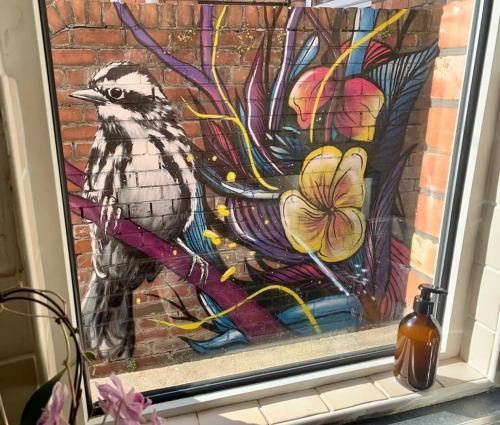 una pintura de un pájaro sentado en una rama en Serene Bristol Home with Sunny Patio Garden en Bristol