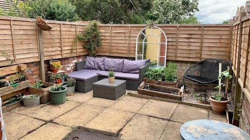 een patio met een paarse bank en een aantal planten bij Serene Bristol Home with Sunny Patio Garden in Bristol