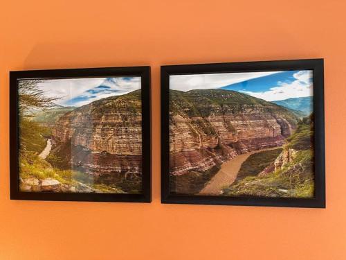 two pictures of a canyon on an orange wall at La Bonita Guesthouse in Bucaramanga