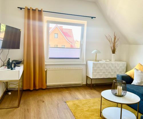 sala de estar con sofá azul y ventana en Ferienwohnung Klein & Fein en Güstrow