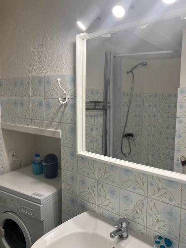 une salle de bain avec douche et lavabo et une machine à laver dans l'établissement Gîte la Serre - Maison de village au calme et au cœur des plus beaux sites ardéchois, à Grospierres