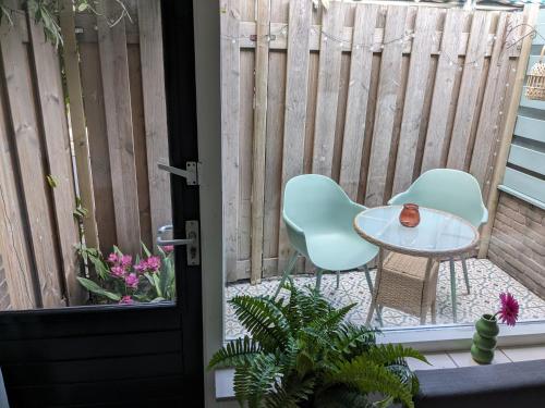 patio con 2 sedie, tavolo e recinzione di zomerhuis in Wijk aan Zee! 2 pers a Wijk aan Zee