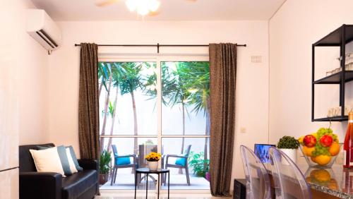 a living room with a large window with palm trees at CityScape Gzira Holiday Apartments and Penthouse in Il-Gżira