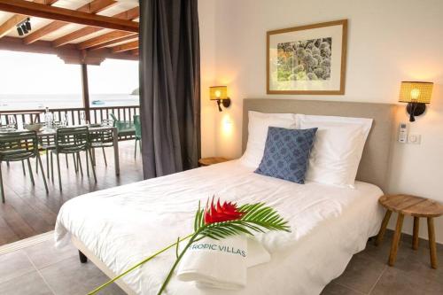 a bedroom with a bed and a balcony with a table at TI PAYOT in Les Anses-dʼArlets