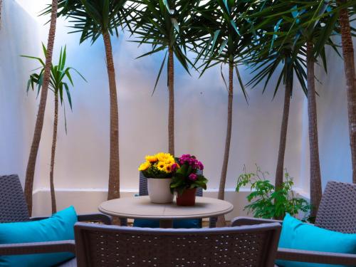 a table with flowers and palm trees at CityScape Gzira Holiday Apartments and Penthouse in Il-Gżira