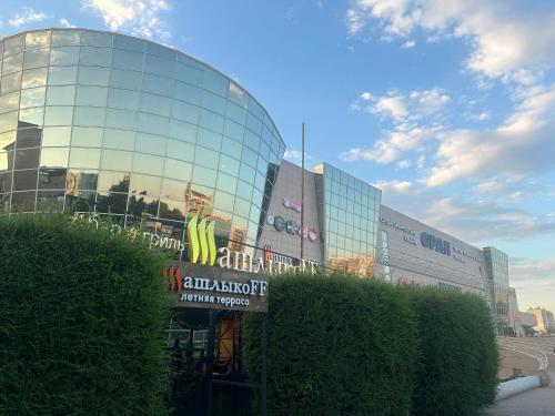 a glass building with a sign in front of it at Уютная и комфортная 3х комнатная квартира со всеми условиями in Uralsk