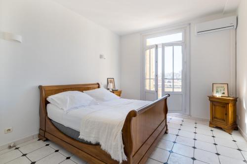um quarto com uma cama grande e uma janela em Splendide vue sur ND de la Garde et le Vieux Port em Marselha