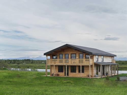 a log house with a black roof in a field at Laxá Lodge in Hella
