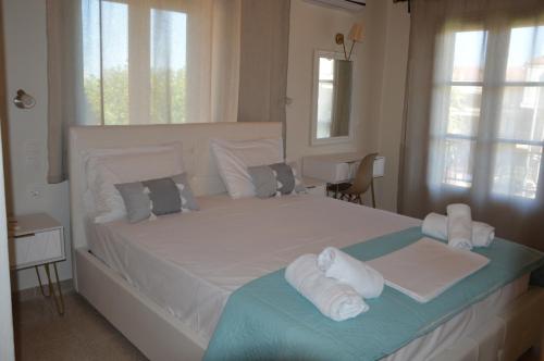 a bedroom with a large white bed with towels on it at Elite Suites in Afitos