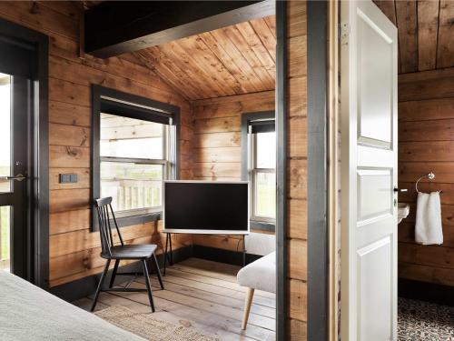a bedroom with wooden walls and a tv in a room at Laxá Lodge in Hella