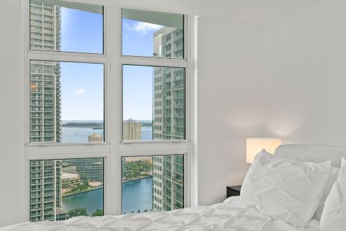 a bedroom with a window with a view of the city at Skyline Serenity - Brickell On The River 1901 - Bi-Level Loft with Breathtaking Views On The Ocean in Miami