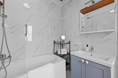 een witte badkamer met een bad en een wastafel bij White Imperial Apartment in Pula