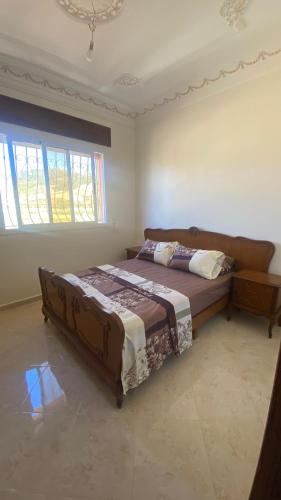 un dormitorio con una cama y una ventana en Big appartement in ksar sgher and close, en Alcazarseguir