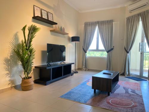 a living room with a flat screen tv and a table at Desaru Private Beach VIP Family Suite NetFlix in Bandar Penawar