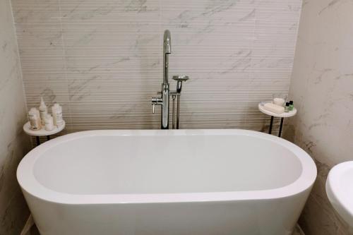 uma banheira branca na casa de banho com um lavatório em No.12 In The Heart Of Blackpool em Blackpool
