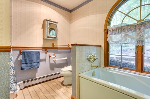 a bathroom with a tub and a toilet and a window at Sparrow Bush Retreat with Fireplace and Screened Porch in Sparrow Bush