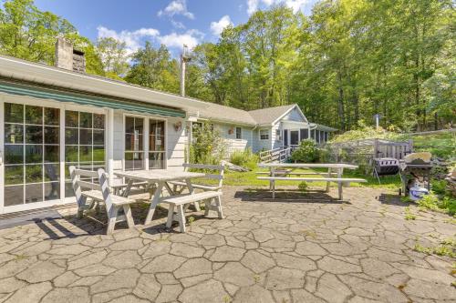 a patio with a table and benches in front of a house at Sparrow Bush Retreat with Pool and Screened Porch in Sparrow Bush