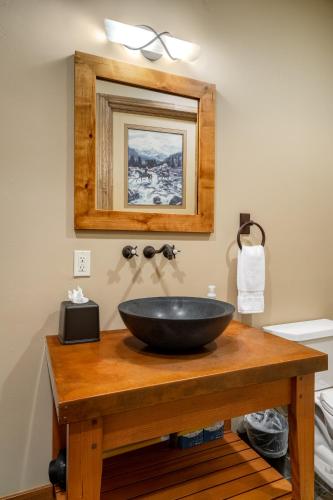a bathroom with a black bowl sink on a wooden table at The Porches in Steamboat Springs