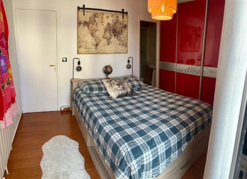 ein Schlafzimmer mit einem Bett mit einer blauen karierten Decke in der Unterkunft Chambre salle de bain privée à 20 minutes de Paris in Fontenay-sous-Bois