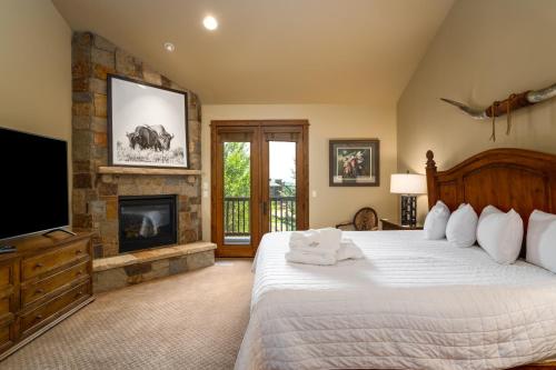 a bedroom with a large bed and a fireplace at The Porches in Steamboat Springs