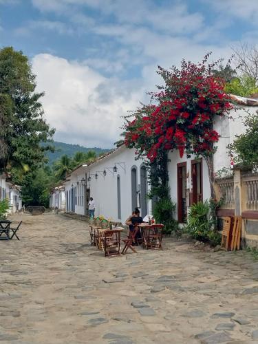 a man sitting at a table in front of a building at Pousada Brilho De Paraty in Paraty