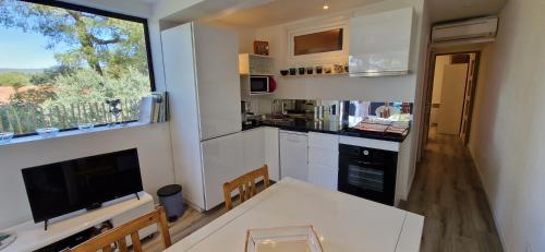 a small kitchen with a white table and a window at D'art d'art à Sanary in Sanary-sur-Mer